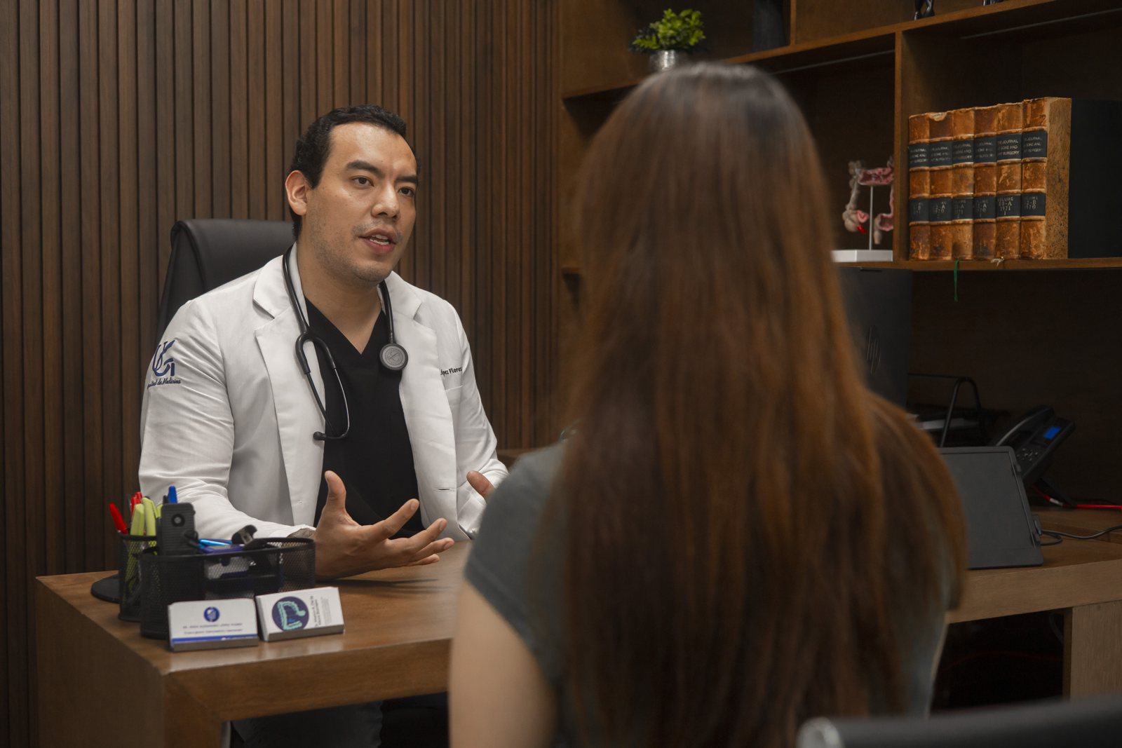Dr. Alexandro López en consulta con una paciente